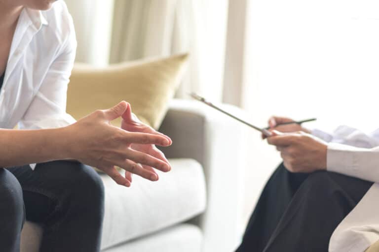 Woman in a therapy session sitting on the couch with a therapist